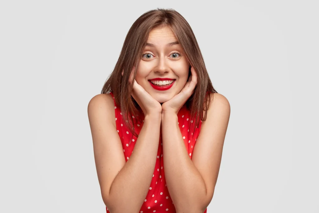 Woman showing a bright, confident smile representing Hollywood smile vs teeth whitening in Dubai cosmetic dentistry options