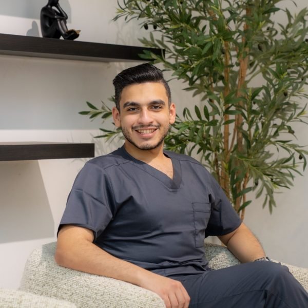 Dr. Mohamed Sharshera sitting comfortably in his trusted dental clinic in Dubai, showcasing a calm and professional environment with modern decor and greenery.